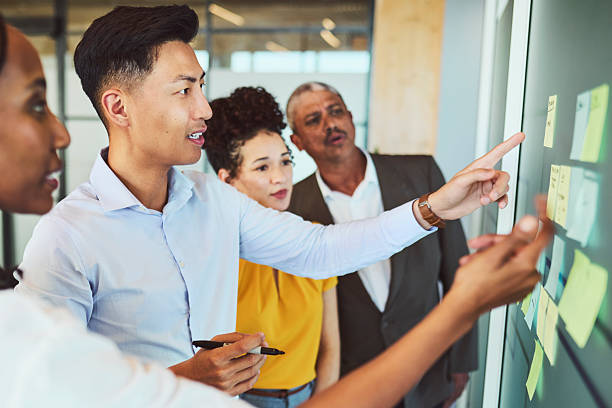 istock Asian Man Leading Diverse Team Strategy Session with Sticky Notes 2240930775