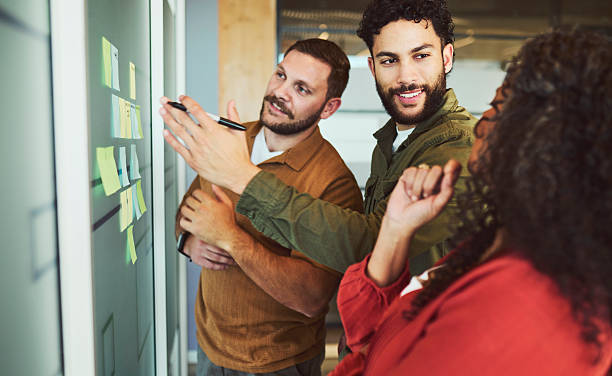istock Diverse Team Actively Brainstorming with Sticky Notes on Glass Wall 2240930781