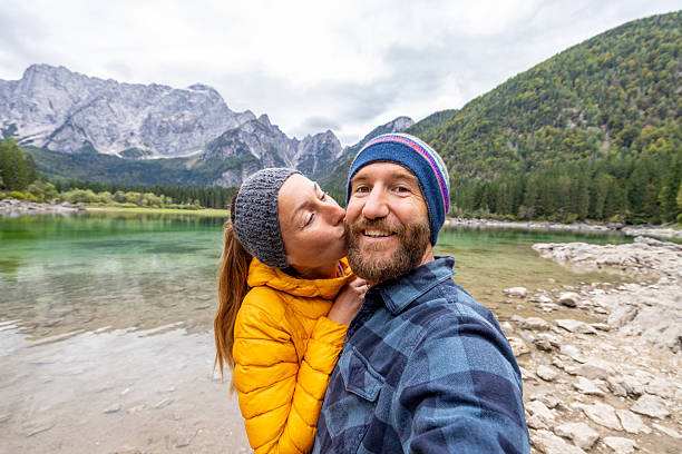 istock Couple Taking Selfie by Mountain Lake 2240931126