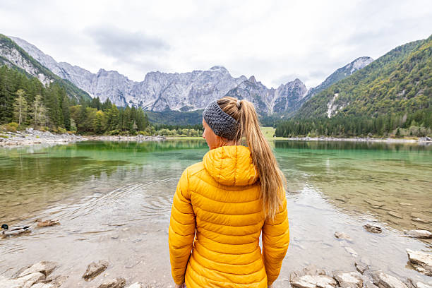 istock Woman in Yellow Jacket by Mountain Lake 2240931344