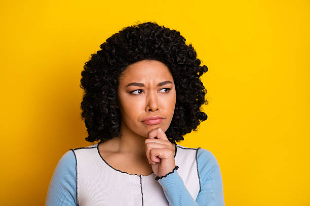 istock Confident young woman with curly hair making a thoughtful expression against bright yellow background 2240931426