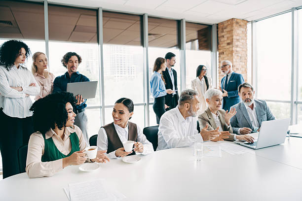 istock Diverse group of professionals collaborating in a modern office during a team meeting with discussions and coffee breaks 2240931996