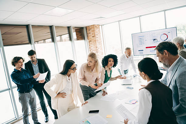 istock Group of business professionals collaborating energetically in a modern office setting, analyzing documents 2240932070