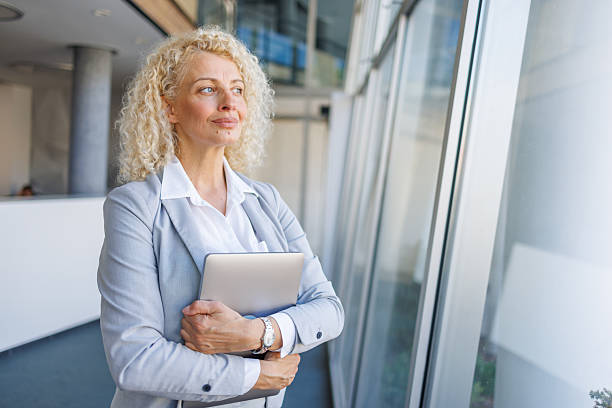istock Confident mature businesswoman looking forward holding laptop 2240932183