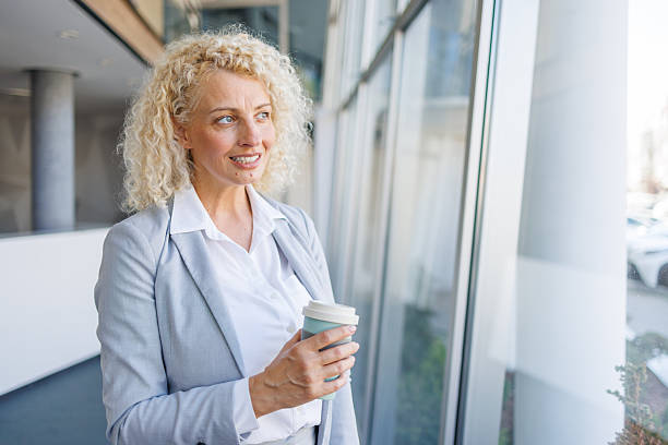 istock Businesswoman taking a coffee break looking out office window 2240932216