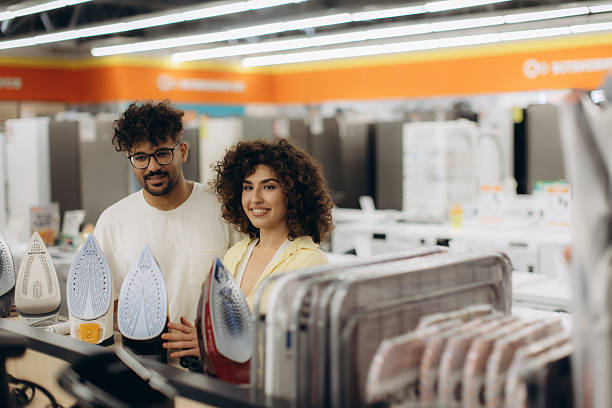 istock Couple Browsing Electric Irons in a Modern Electronics Store 2240932653