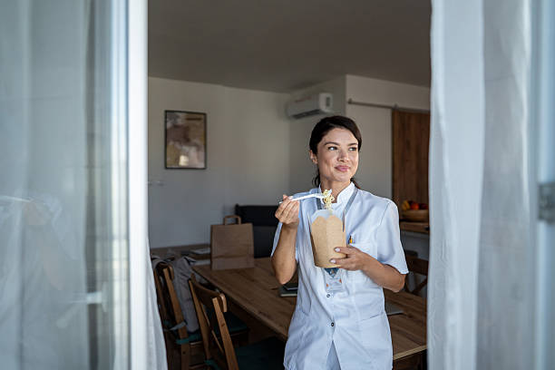 istock Female nurse eating takeout noodles on break 2240933790