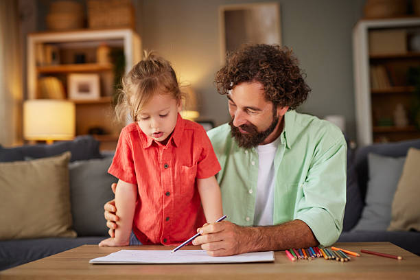 istock Father and daughter drawing together at home 2240933882