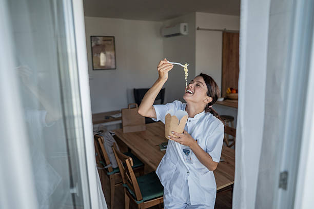istock Nurse enjoying takeout noodles during a much-needed break 2240933935
