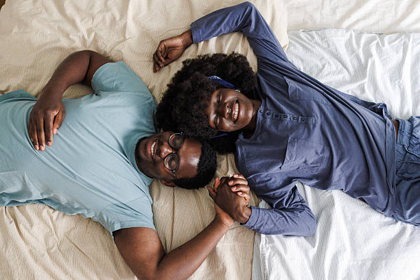 istock Relaxed African American couple holding hands while lying in bed 2240935365