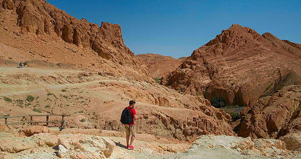 istock Man climbing the mountains in Sahara desert. 2240935390