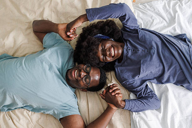 istock Relaxed African American couple holding hands while lying in bed 2240935399