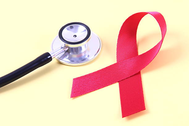 istock AIDS awareness red ribbon and stethoscope on yellow background 2240936921