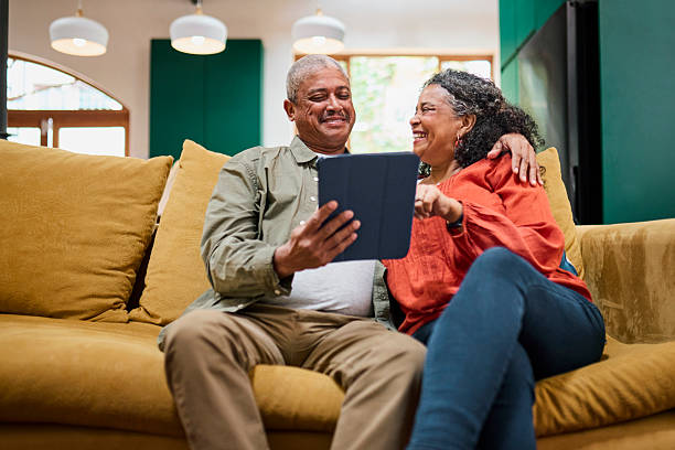 istock Senior Black Couple Laughing and Using Digital Tablet Together on Sofa 2240936987