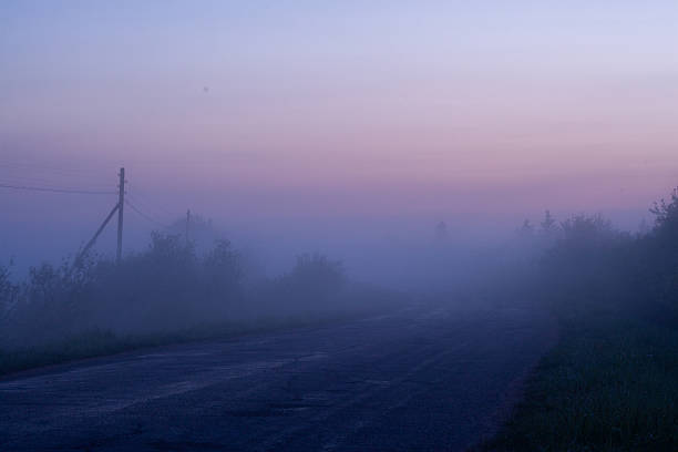 istock Mysterious Foggy Road at Twilight 2240940989