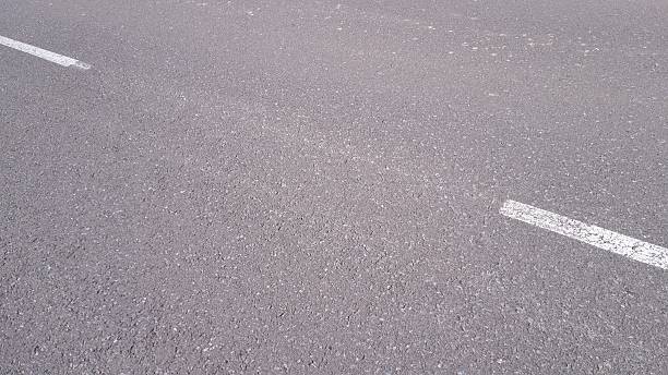 Close-up texture of asphalt road with white markings