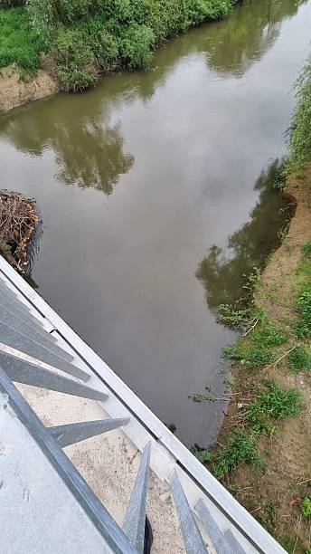 istock Calm river viewed from metal bridge with reflection on water surface 2240941093