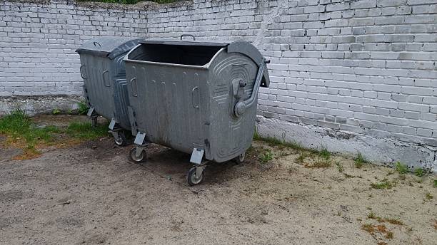 istock Metal dumpsters with wheels near old brick wall outdoors 2240941393