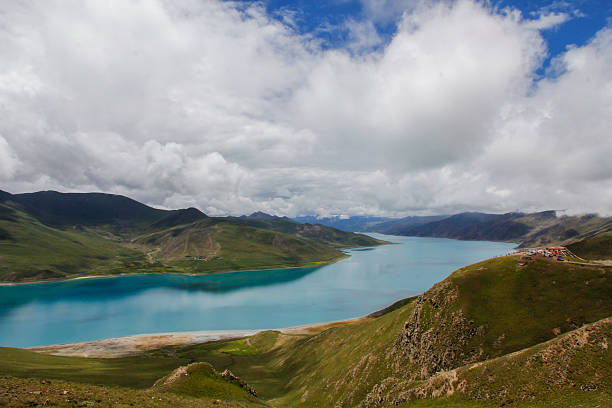istock Breathtaking turquoise lake surrounded by green mountains under cloudy sky 2240942000