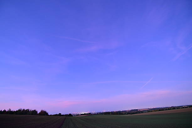 Night sky with stars and clouds over a peaceful field, beautiful nature composition and atmospheric landscape.