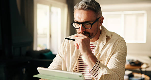 istock Remote work from home, thinking and man with tablet, pen and planning for creative project. Artist, entrepreneur and mature person with tech, decision and freelancer with ideas, app and online design 2240947441