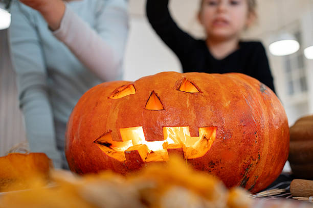 Family enjoying Halloween preparations by carving a pumpkin