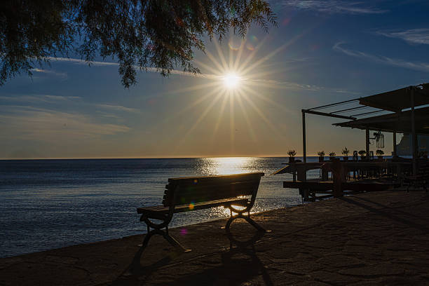 istock A serene seaside view at sunset with a bench and a pier. 2240952837