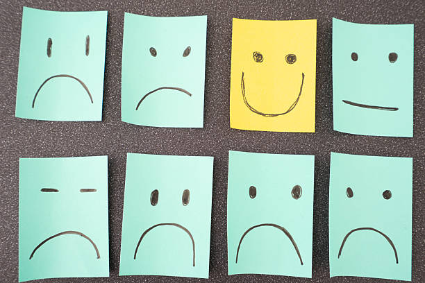 istock Sticky notes with unhappy smiley's and one happy smiley. 2240955222