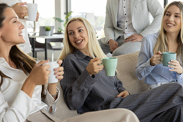 istock Three smiling businesswomen relax and chat on a sofa 2240955579