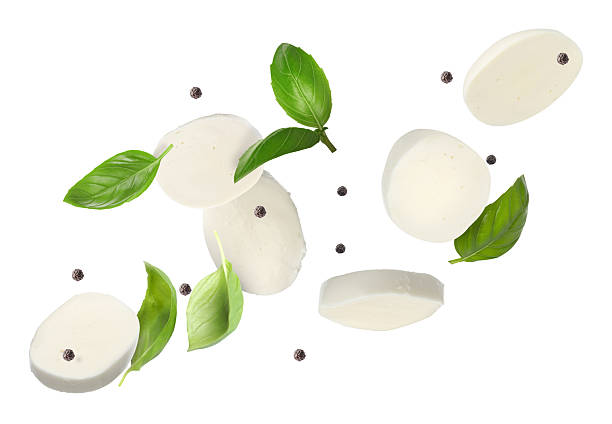 istock Mozzarella cheese and basil leaves flying against white background 2240958557