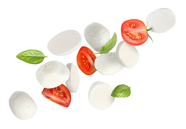 istock Mozzarella, tomatoes and basil leaves flying against white background 2240958581