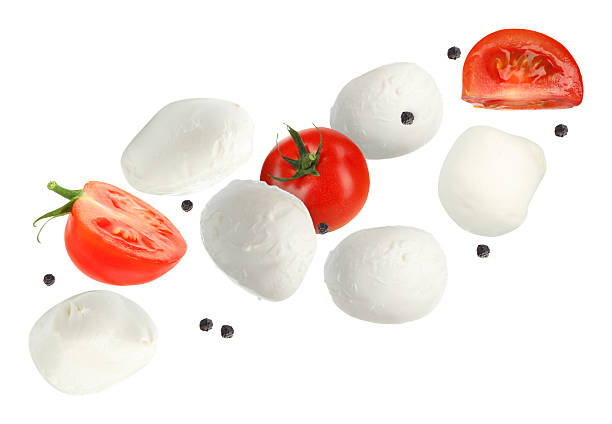 istock Mozzarella cheese and tomatoes flying against white background 2240958674