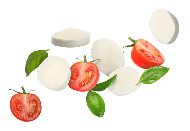 istock Mozzarella cheese, tomatoes and basil leaves flying against white background 2240958709