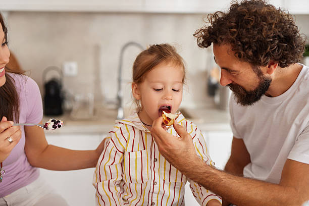 istock Parents feeding child healthy breakfast in kitchen at home 2240962938