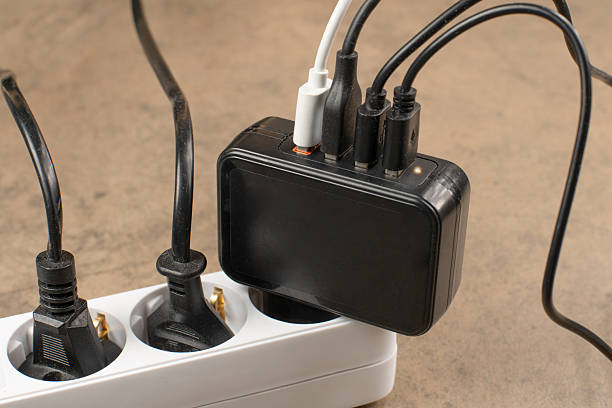 istock Extension power outlet socket overloaded with plugs, USB adapter with charge cables plugged into power strip 2240963296