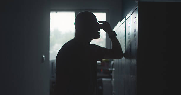 istock Depressed man leaning against the wall in a dark hallway with face in hands 2240963756