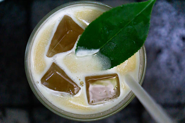 istock A refreshing mango cold brew is captured from above, featuring ice cubes, a vibrant green leaf garnish, and a straw, highlighting its creamy texture and rich colors. 2240965730