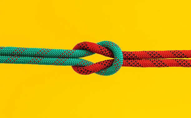istock Red and green ropes with reef knot isolated on yellow background 2240966330