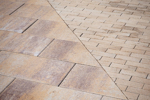 istock Method of laying paving tiles, joints of different textures. Paved surface with two tile patterns meeting at diagonal line. Texture for architecture, landscaping or urban design projects. Real photo. 2240968326