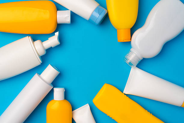 istock Bottles of sunscreen cream on blue background 2240970370