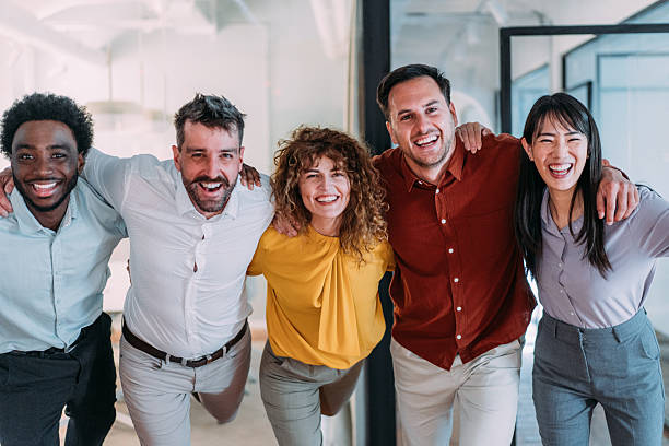 istock Excited coworkers embracing each other during a celebration in the office. 2240975347
