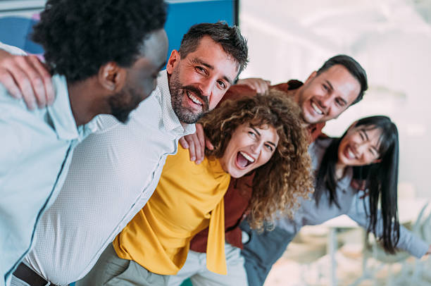 istock Excited coworkers embracing each other during a celebration in the office. 2240975348