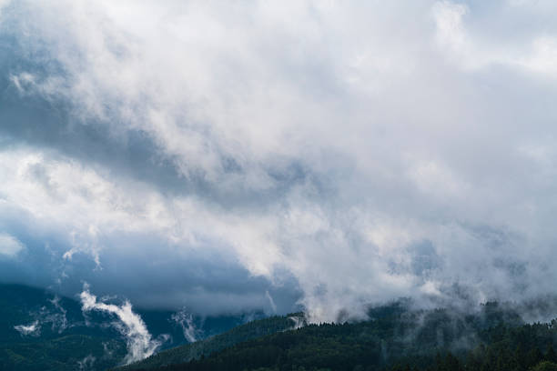 Germany, Mystical schwarzwald nature scenery panorama view above forest mountains, magical moment after sunrise with rain clouds and fog covering the trees