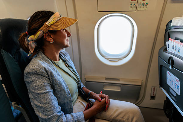 istock Smiling Woman Looking Out the Airplane Window During Flight 2240981493