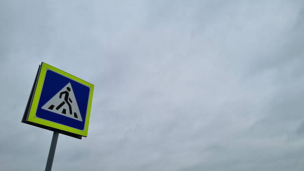 Pedestrian Crossing Sign under Cloudy Sky