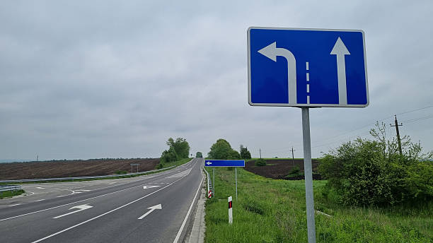 istock Highway intersection with blue road direction sign and cloudy sky 2240981582