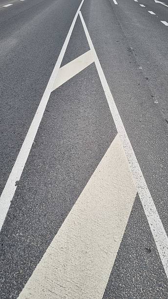 istock Chevron and border lines dividing highway lanes on asphalt surface 2240981603