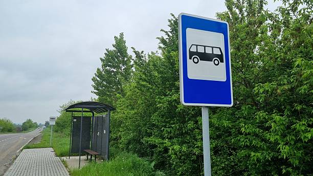 Blue bus stop road sign with rural shelter and greenery background