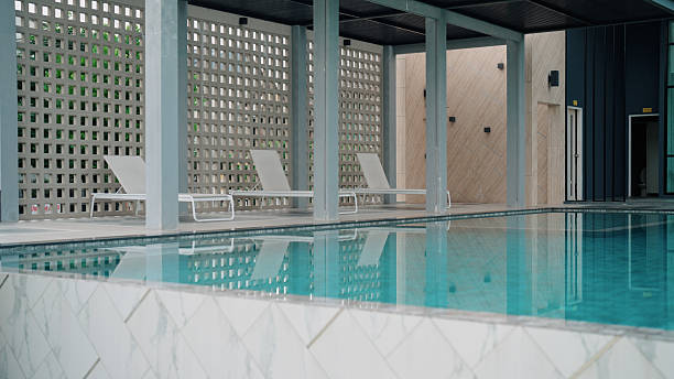 istock Clean public pool area with white chairs lining the poolside 2240982456