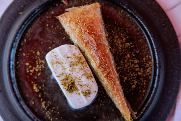 A traditional Turkish dessert featuring Kunefe Saati and baklava, showcasing golden, crispy layers and sweet syrupy textures.